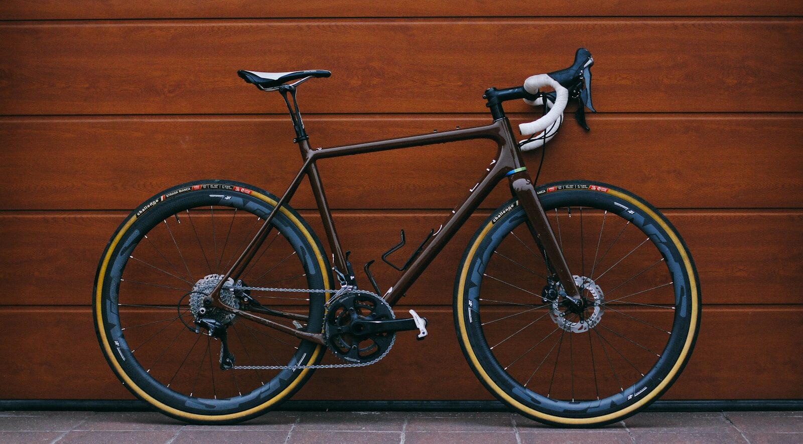 black road bike against wooden wall